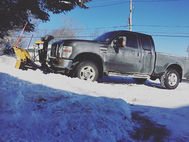 A truck with a snow plow in the snow.