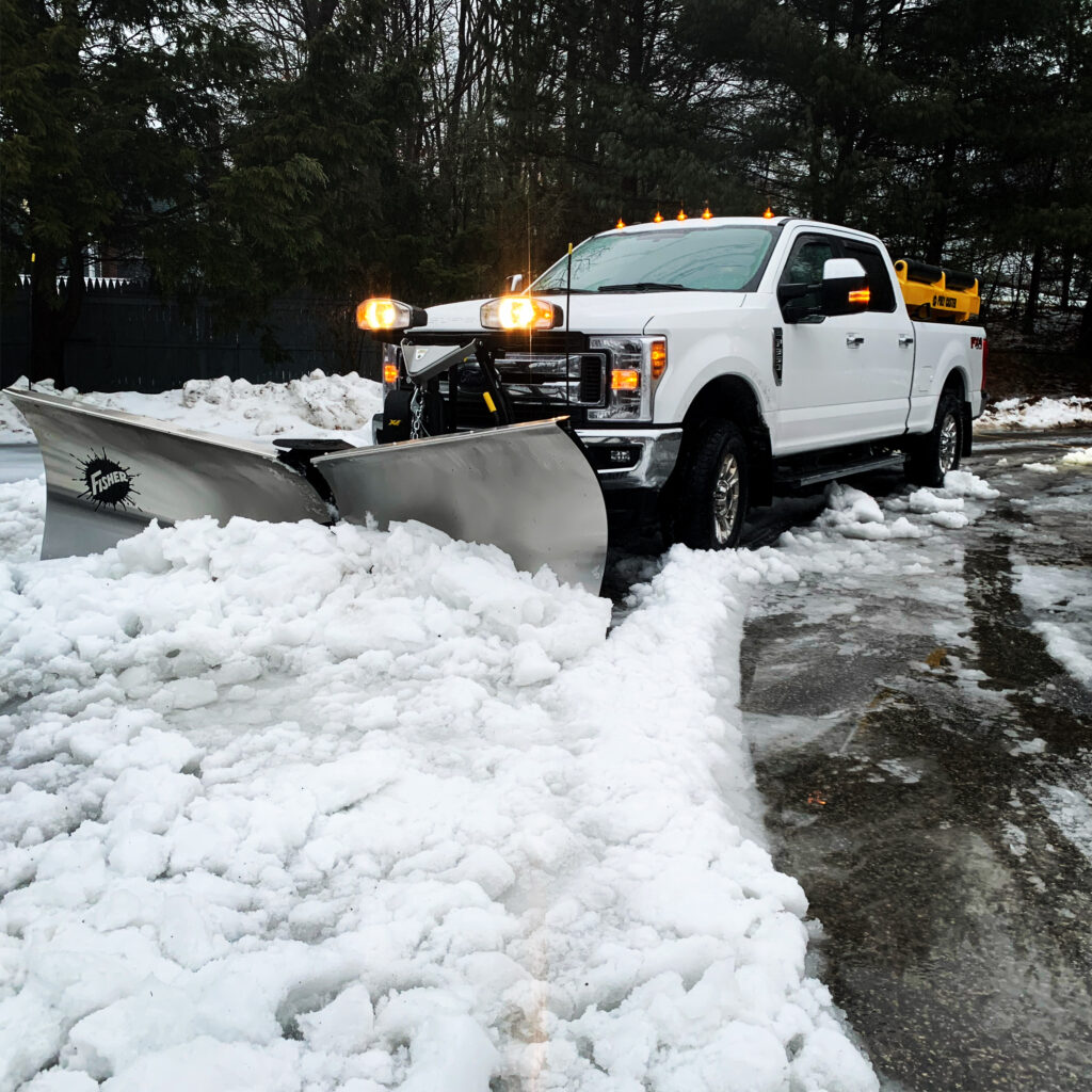 A white truck with a snow plow.