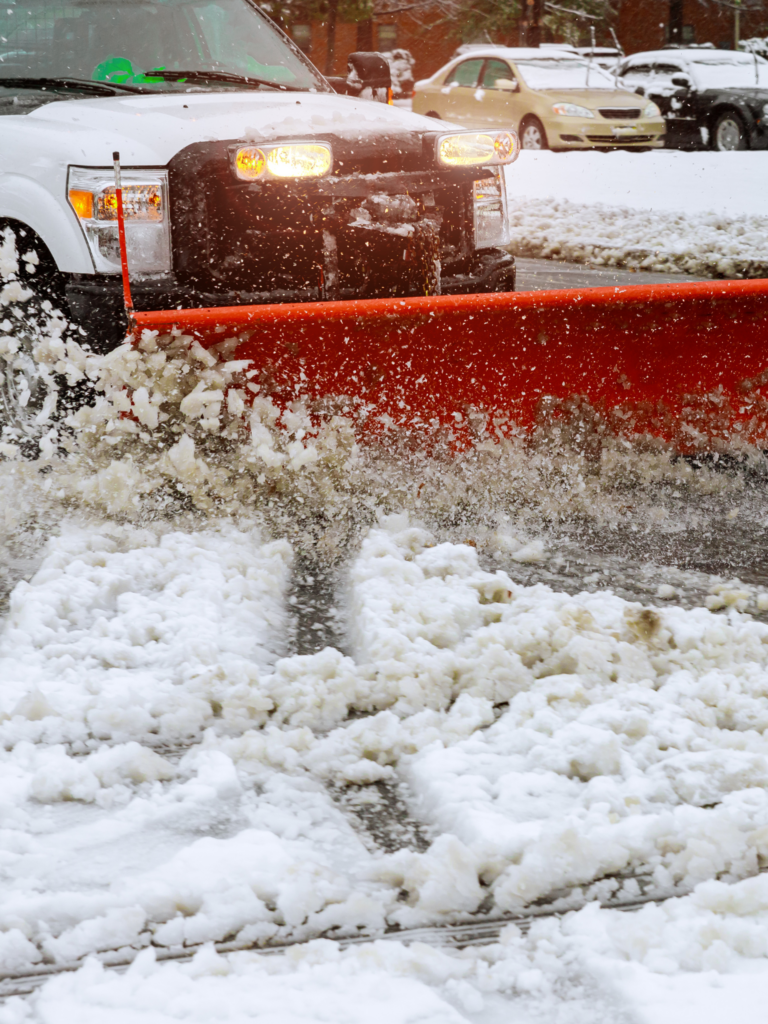 A white truck with a snow plow.