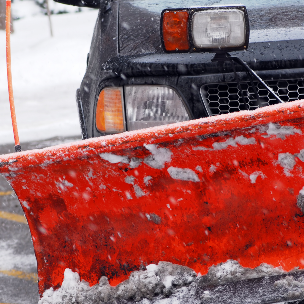 A black car with a snow plow.