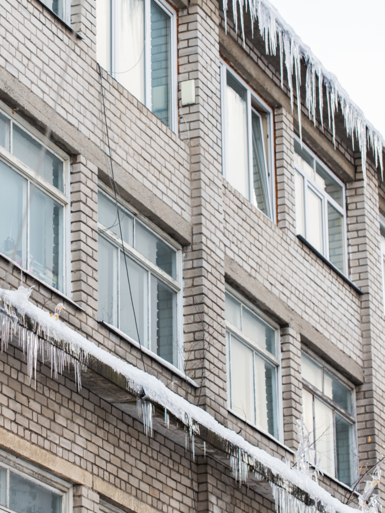 A brick building with icicles on the windows.